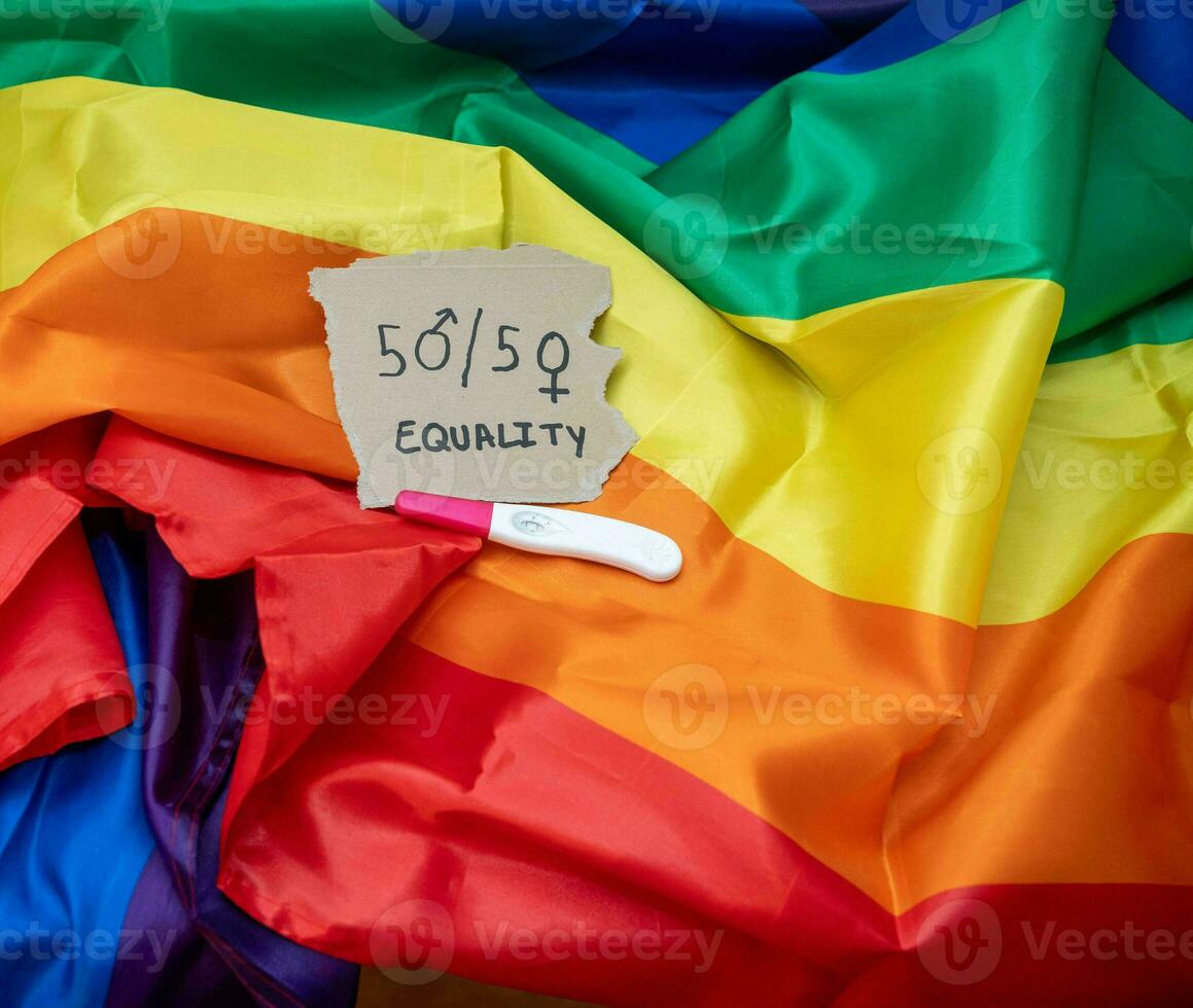 cutout with the phrase 50 percent equality, on a pride flag along photo