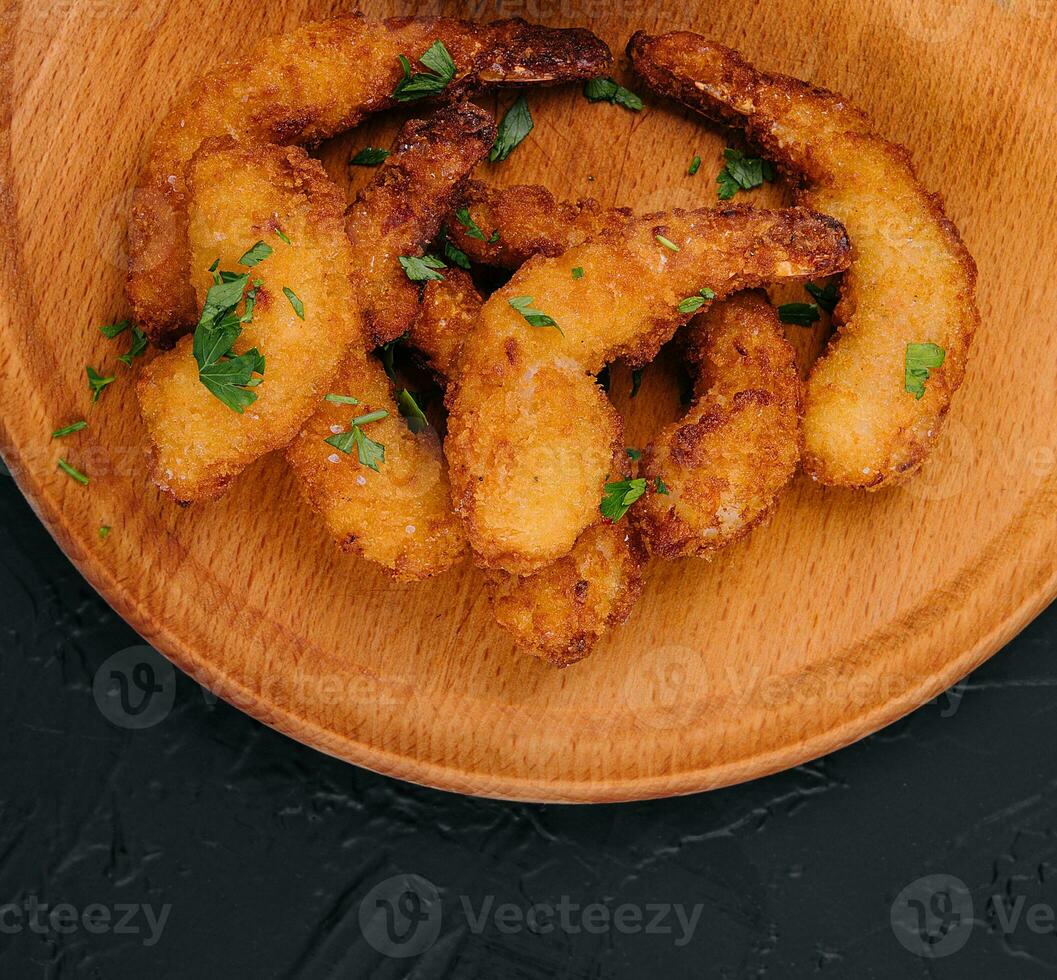 Fried shrimps or prawns with sauce on board photo