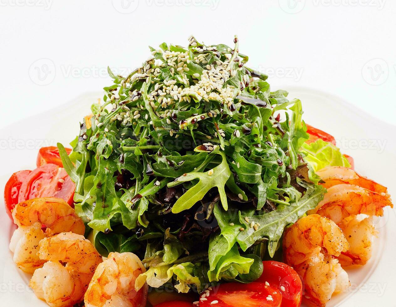 Healthy arugula salad bowl with shrimp, tomato, and sesame seeds photo