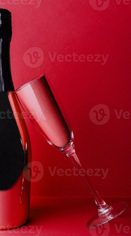 champagne bottle with glass on red background photo