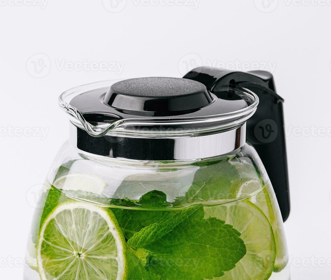 Fruit water with lime and mint in glass pitcher photo