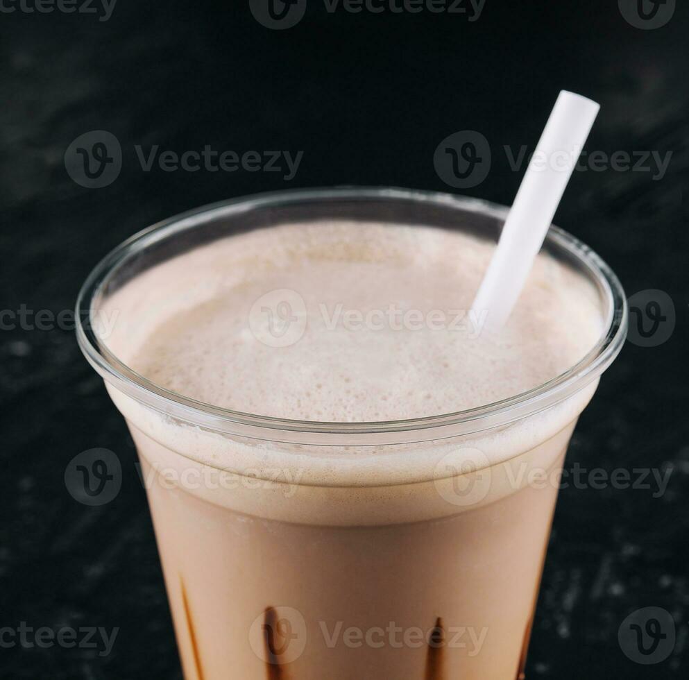 milkshake in a plastic cup on black background photo