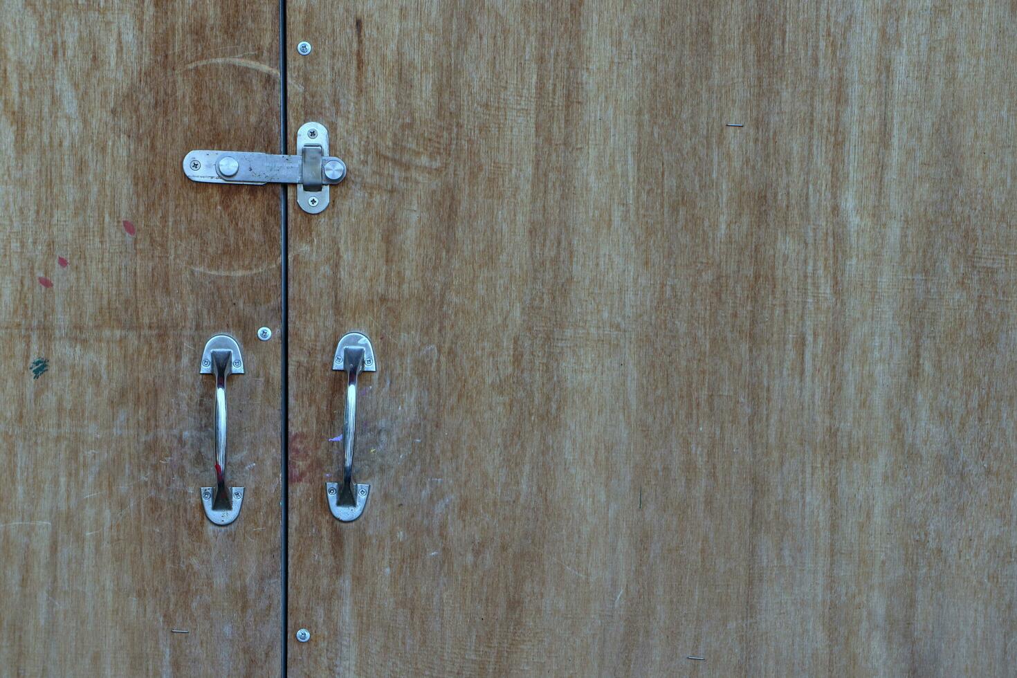 el frente puerta es un grande tablón con metal manejas. foto