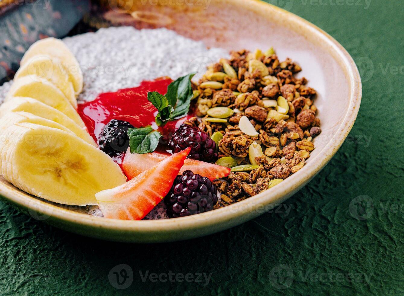 Healthy breakfast bowl of granola, yogurt and fruits photo