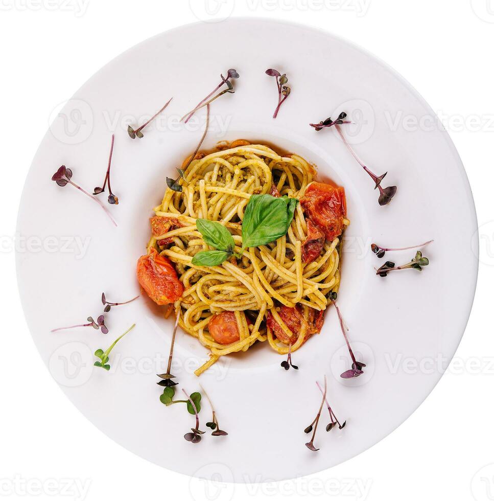 Spaghetti with colorful stewed cherry tomatoes, basil and pesto sauce photo