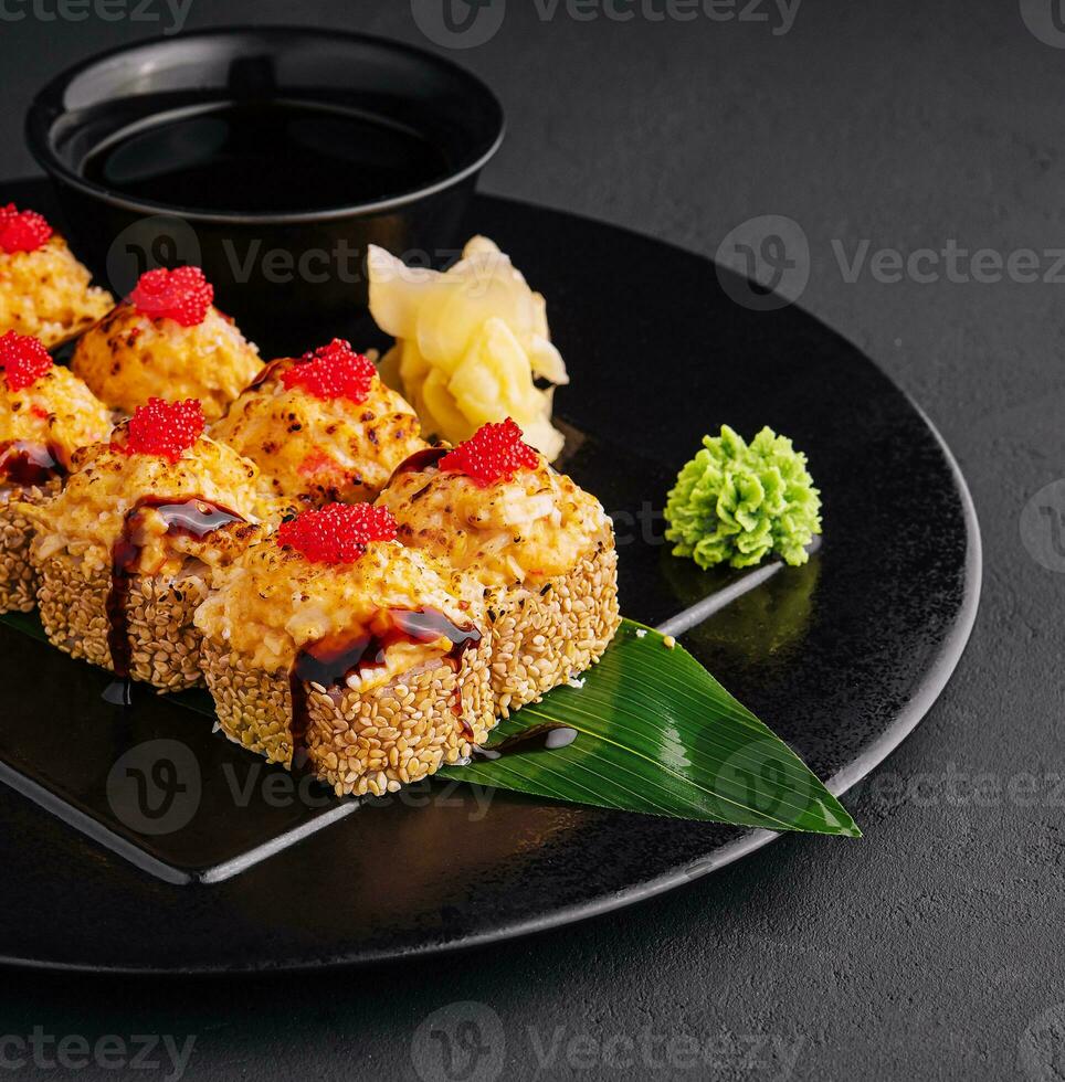 Traditional baked japanese sushi on black plate photo