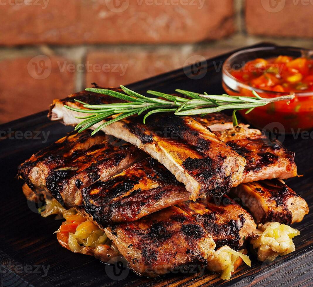 Bbq pork ribs grilled with tomatoes herbs photo