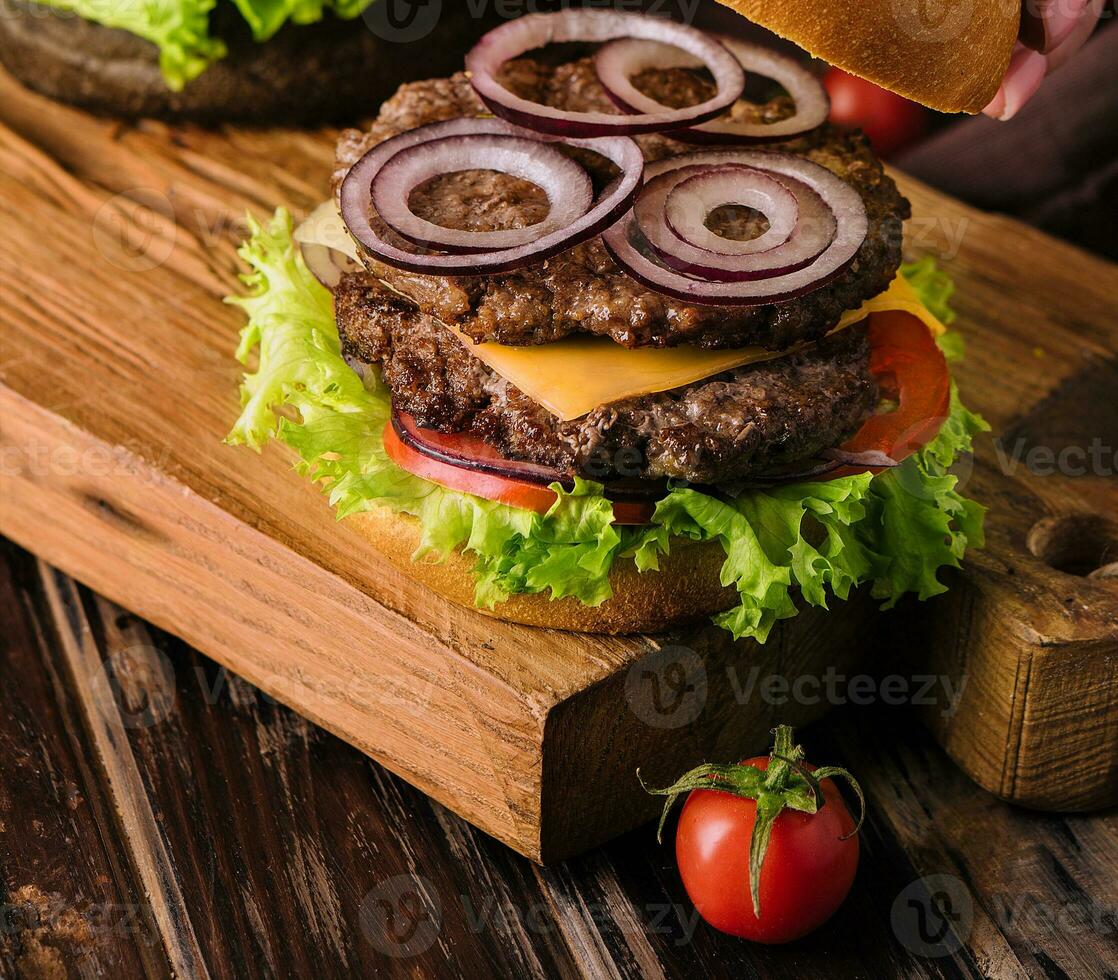 Close up view of female cooking fresh tasty burger photo