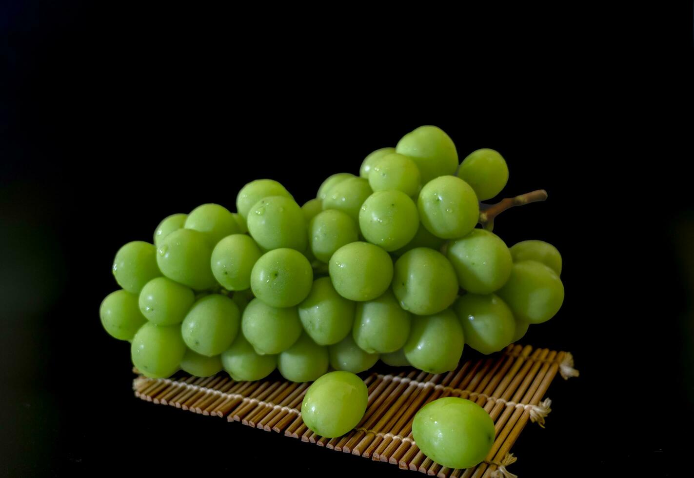 Fresh Shine muscat grapes on black background. photo