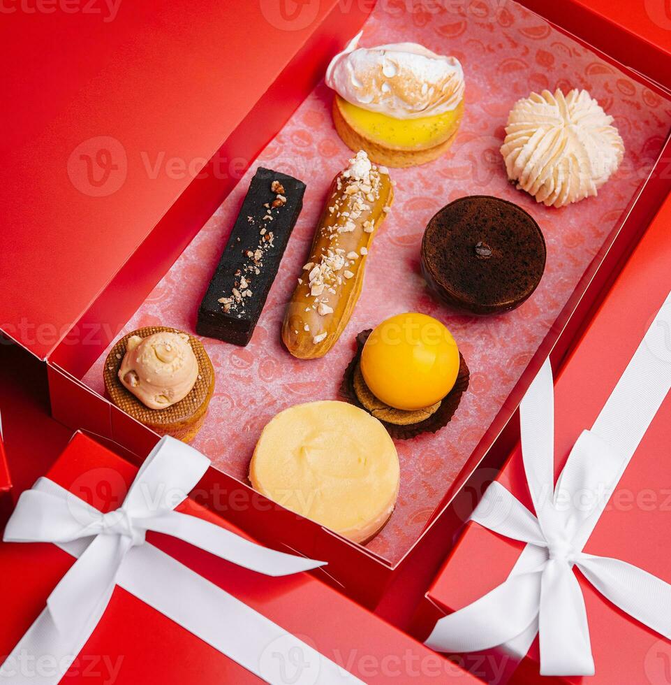 Christmas gifts presents with different cakes on red background photo