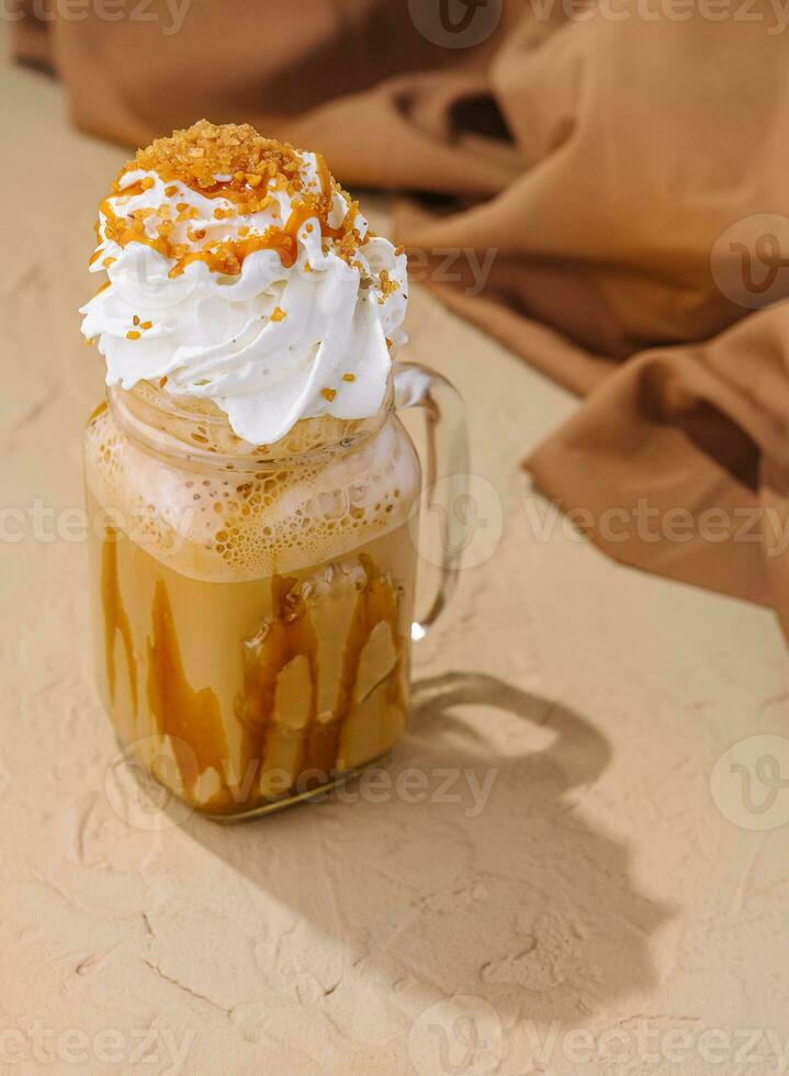 Caramel iced latte with whipped cream and syrup photo