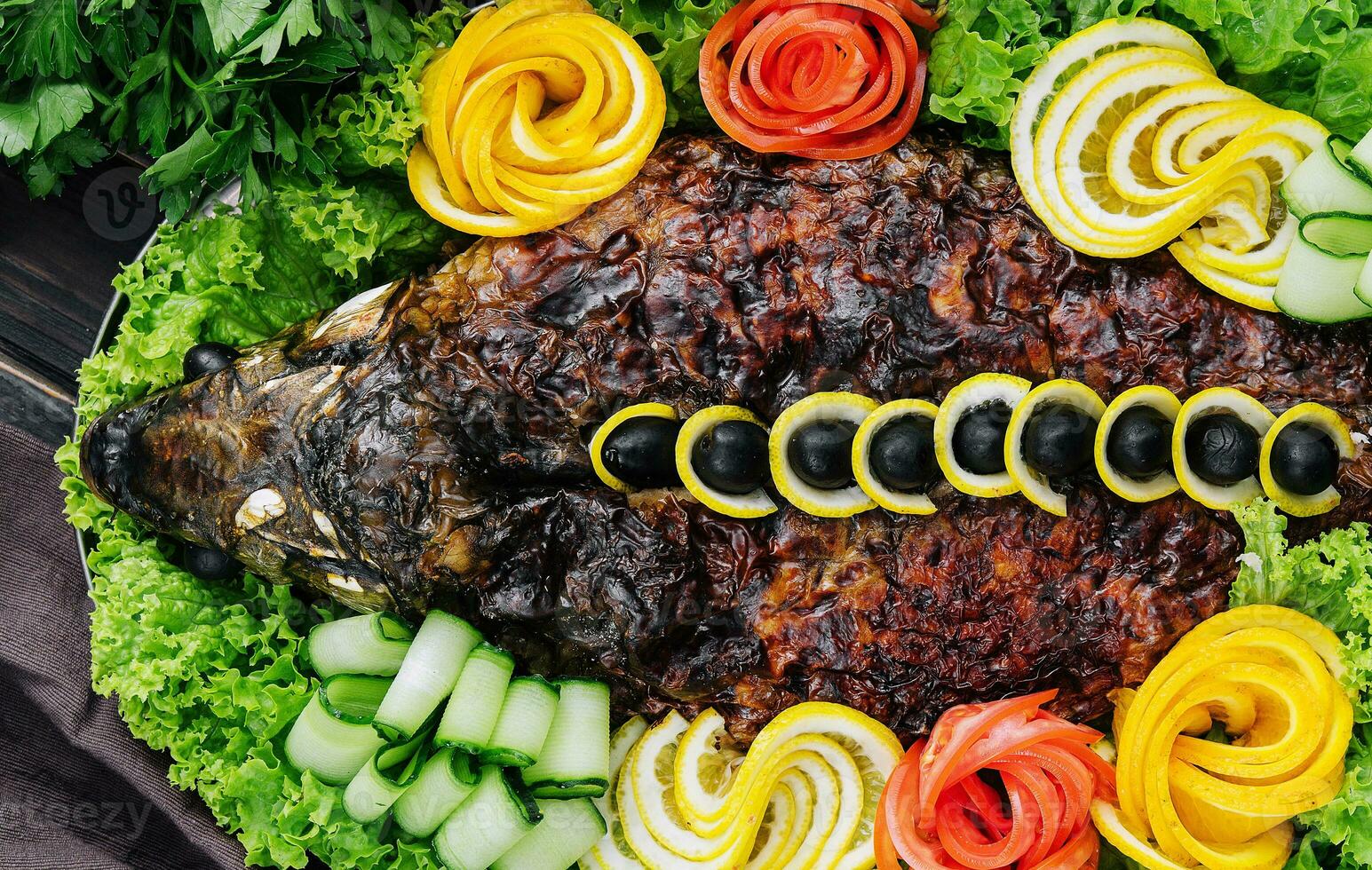 baked carp with vegetables close-up in a baking dish on the table photo