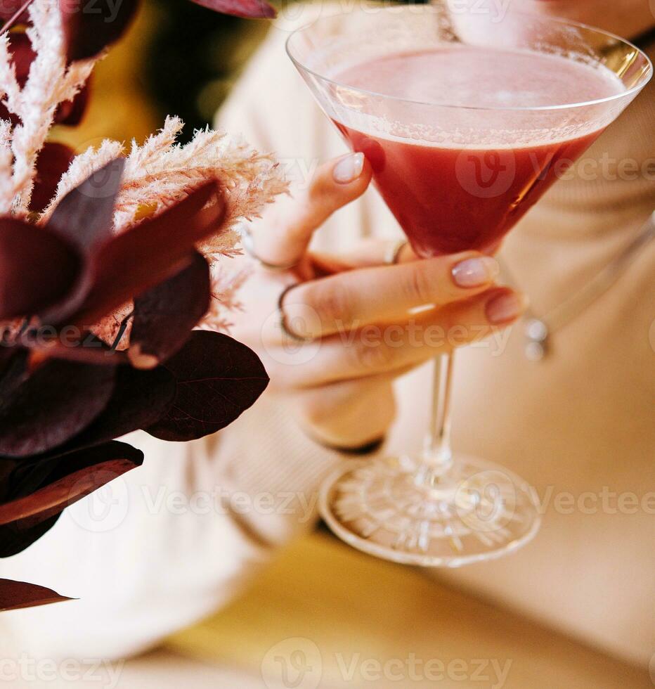 young woman drink red cocktail with strawberry photo