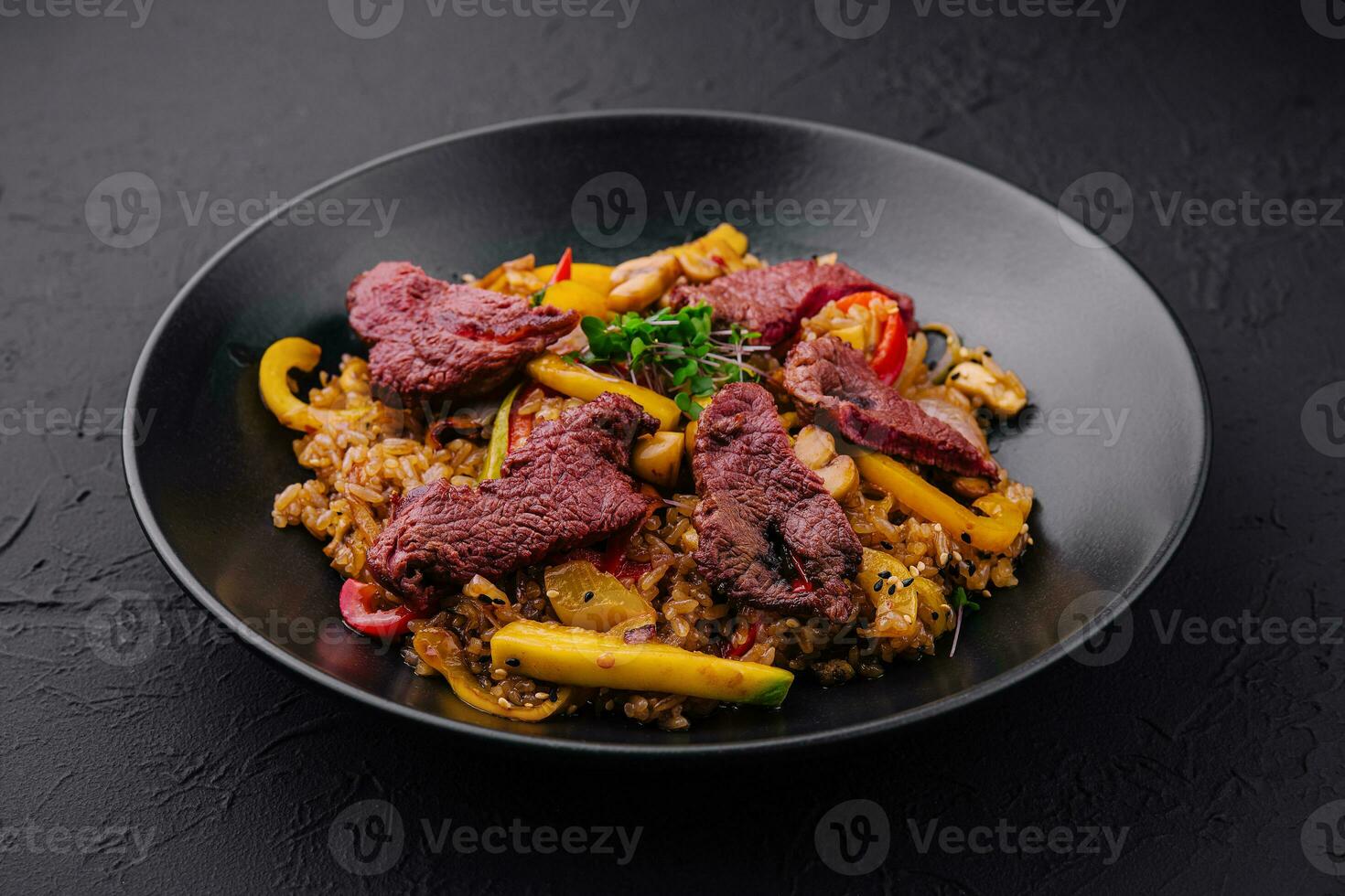 chino frito arroz con carne de vaca en negro plato foto