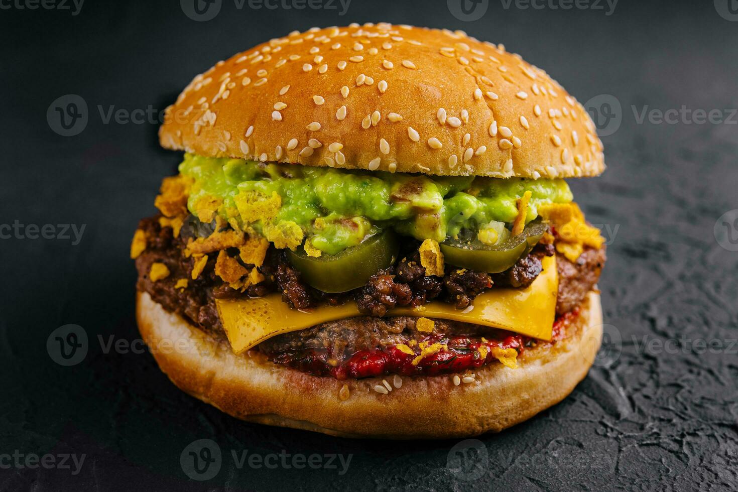 veggie burger with guacamole and pickles on toasted bun photo