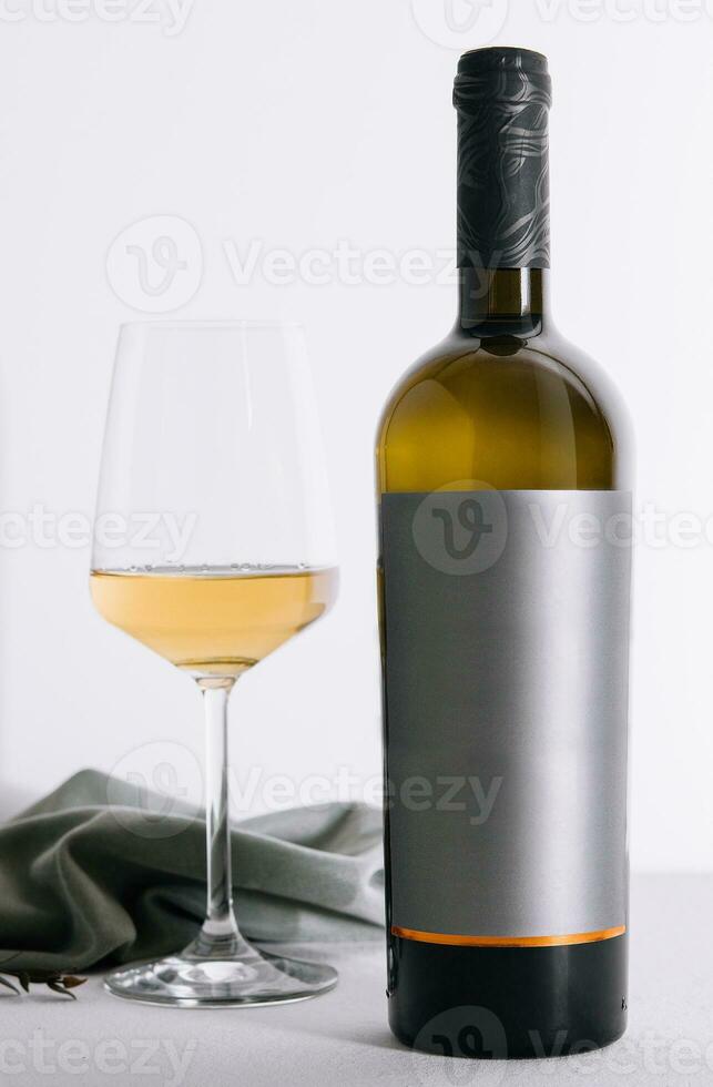 glass and bottle of wine on white photo