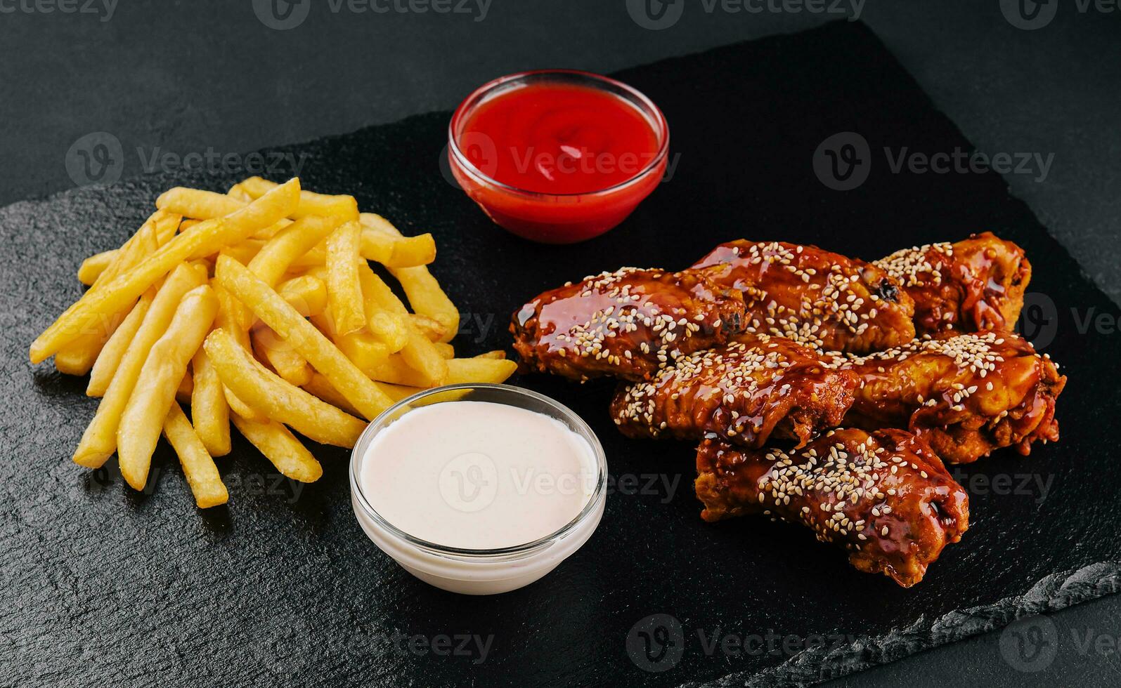 Hot and spicy buffalo chicken wings and french fries photo