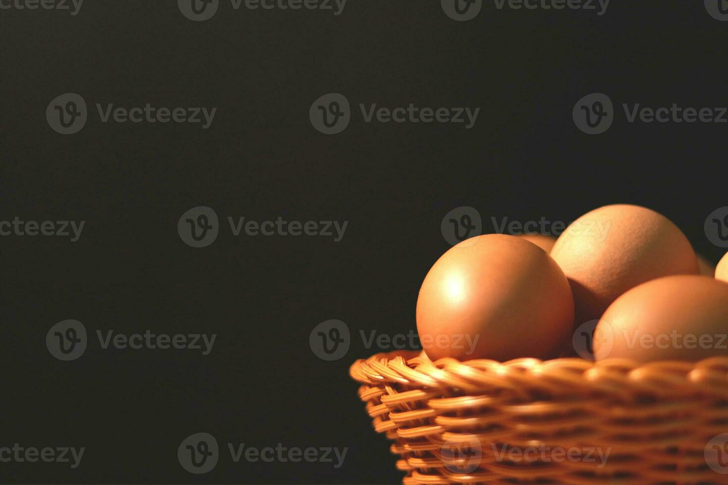 The eggs in the brown wicker basket on the table. photo