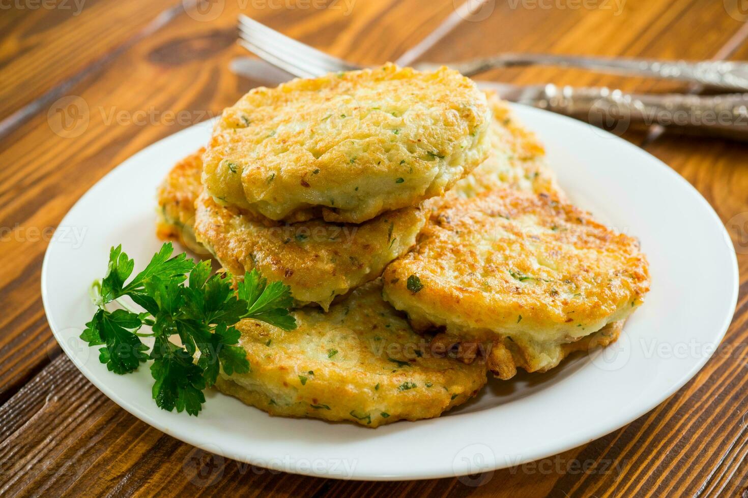 cooked fried potato cutlets with herbs photo