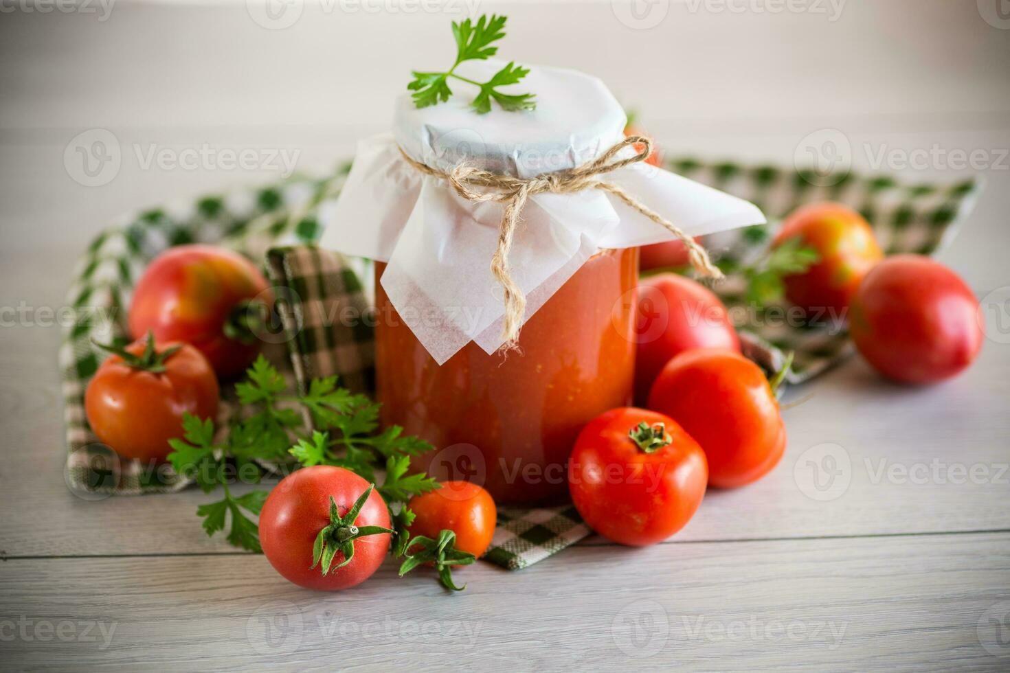 Cooked homemade tomato juice canned in a jar of natural tomatoes. photo
