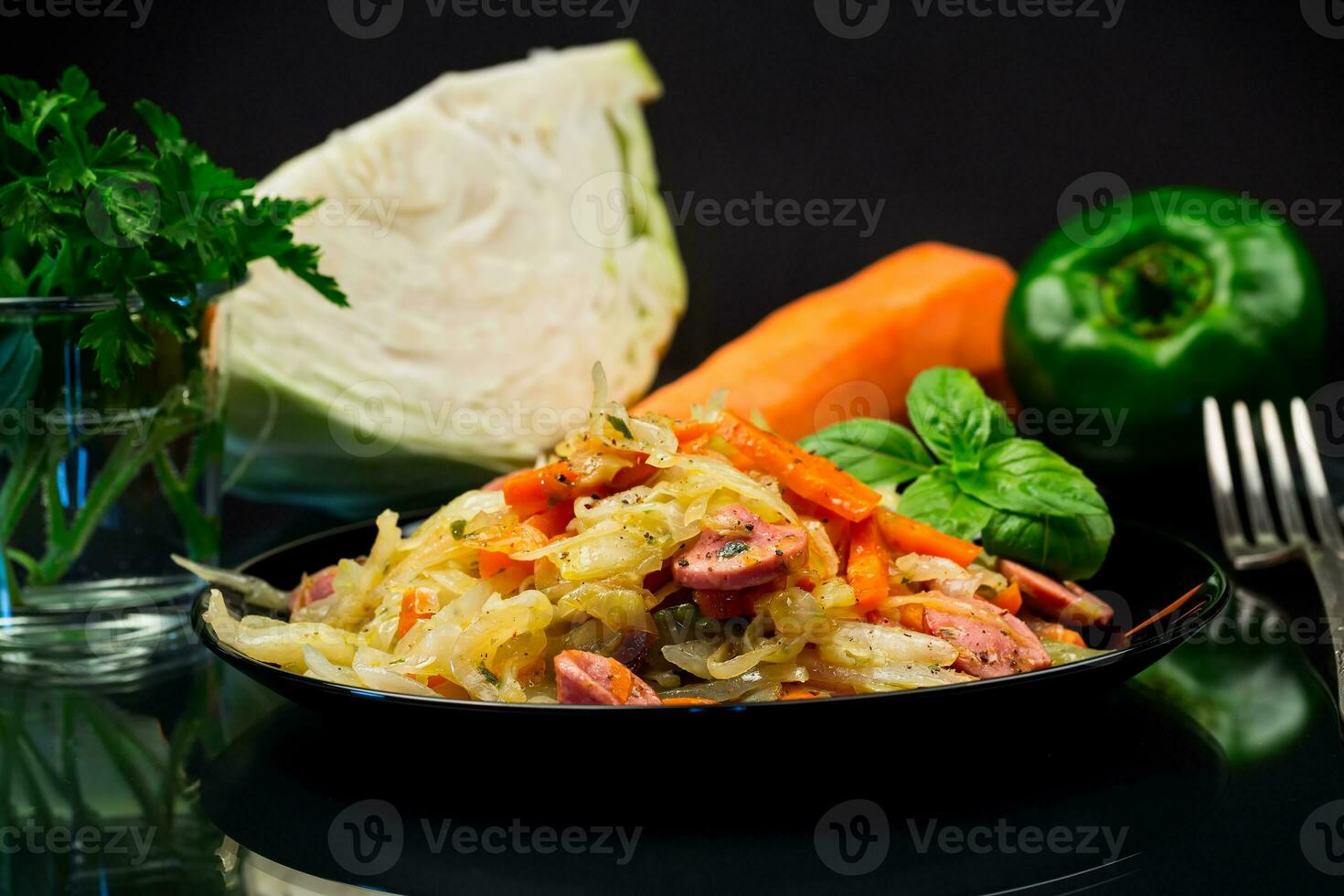 cooked fried cabbage with vegetables and sausages photo