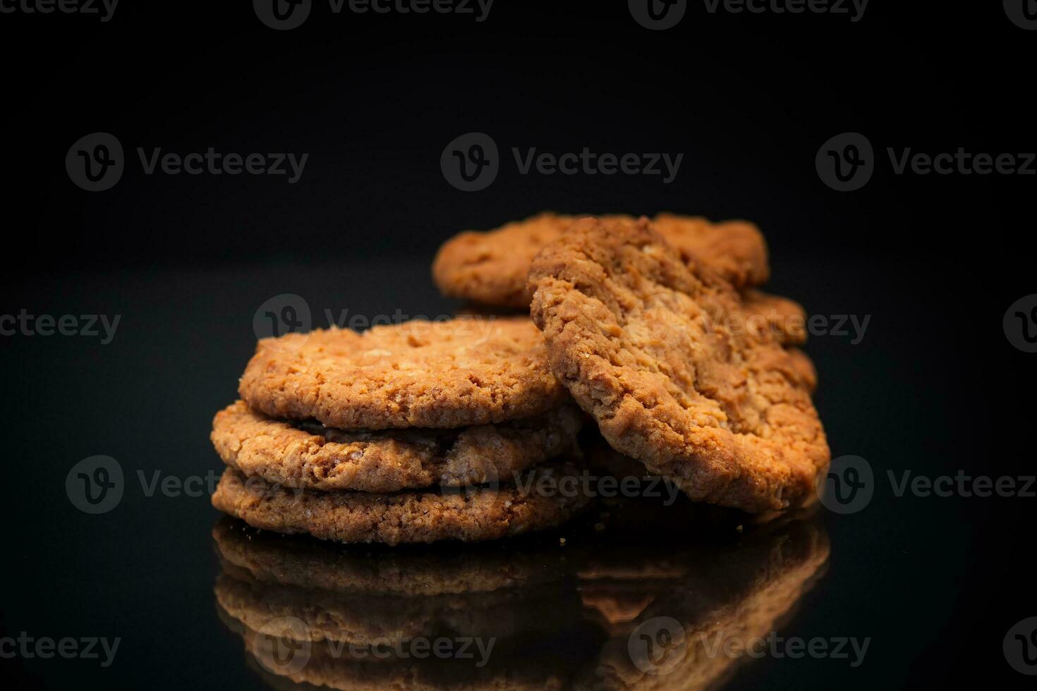 cooked sweet oatmeal cookies on black background photo