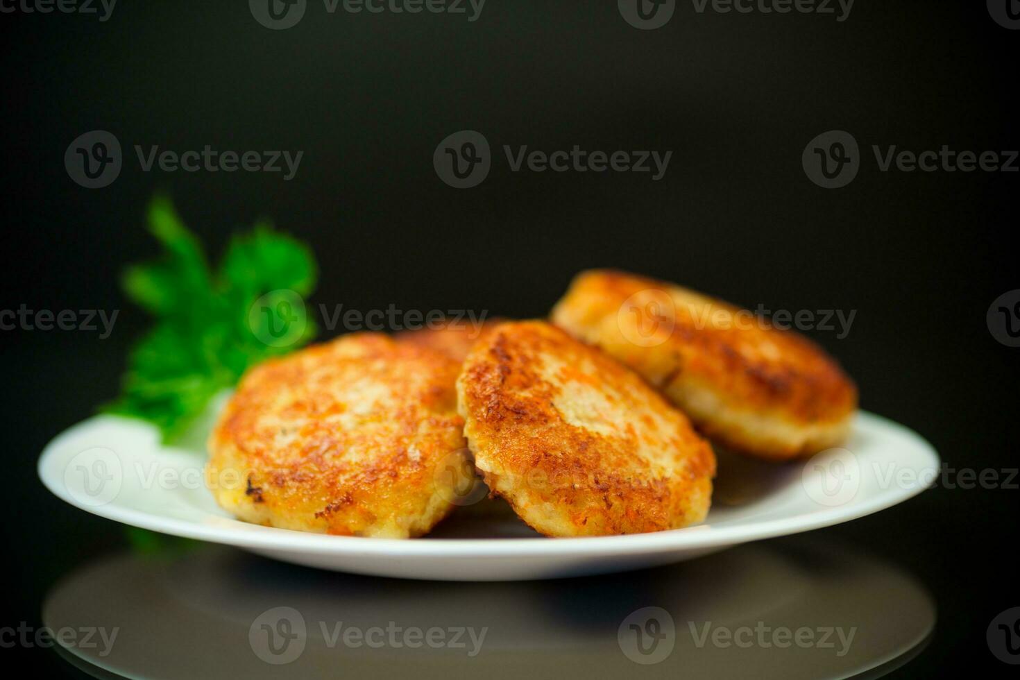 Cooked fried fish cutlets in a plate with herbs. photo