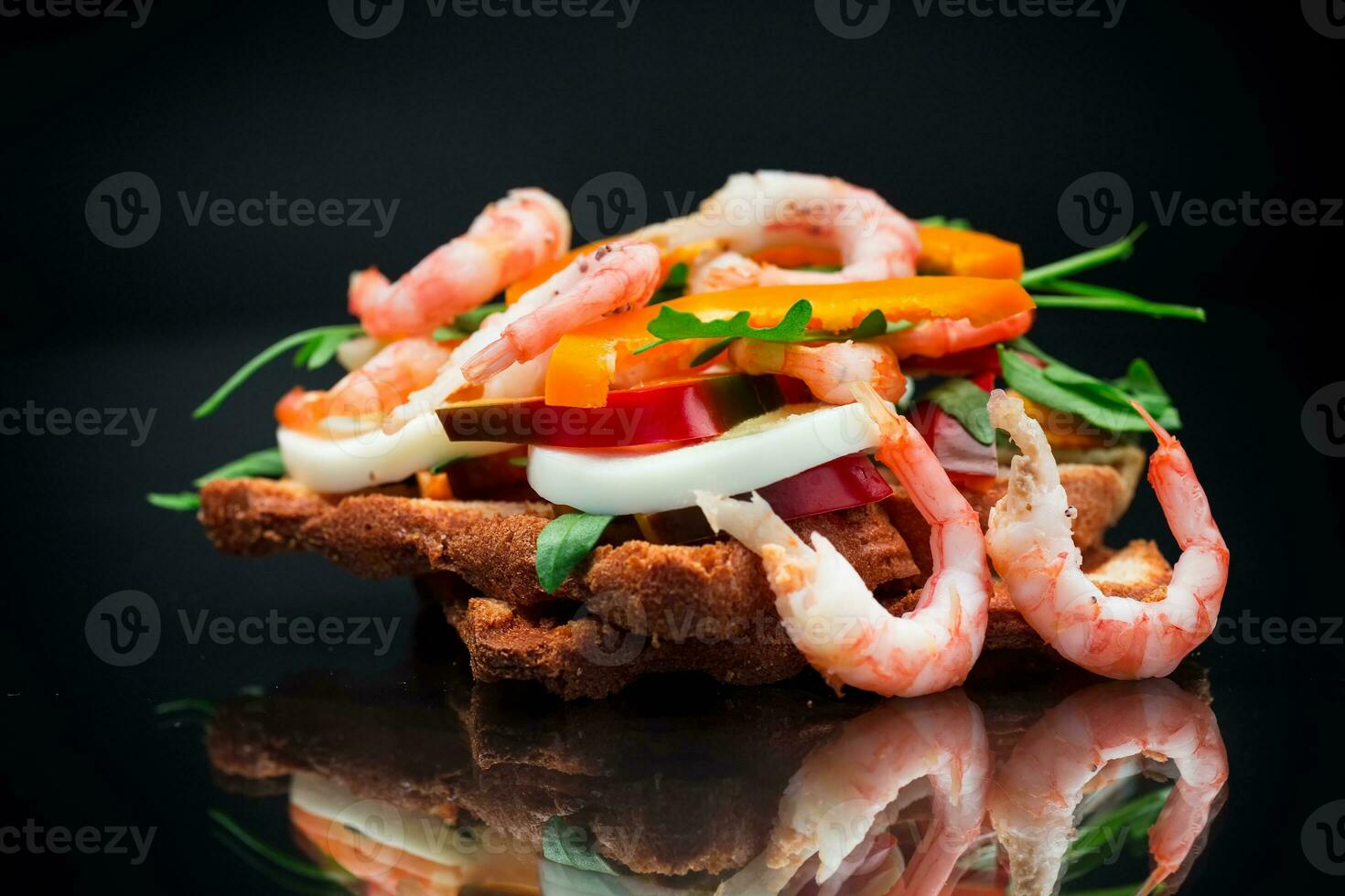 cooked sandwich with shrimp, eggs, pepper and greens photo