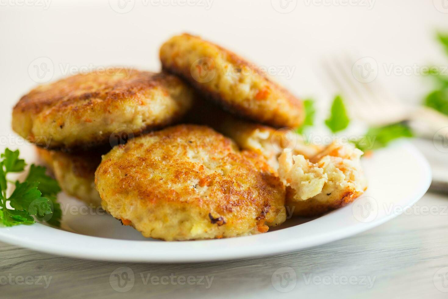 Cooked fried fish cutlets in a plate with herbs. photo