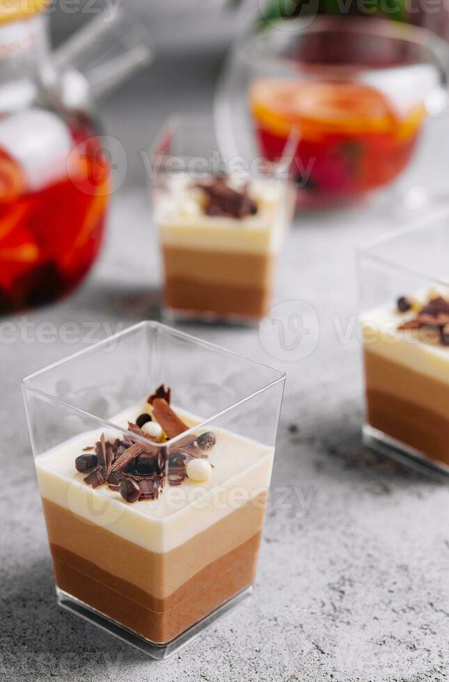 Layered dessert Trifles in a transparent glasses photo