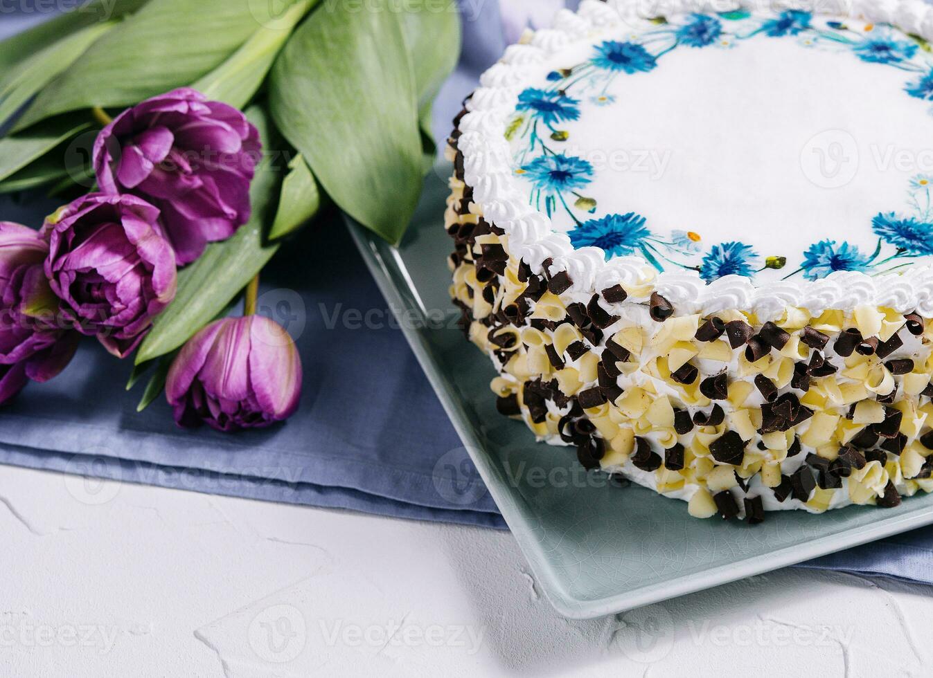 cake with white cream and flowers tulips photo