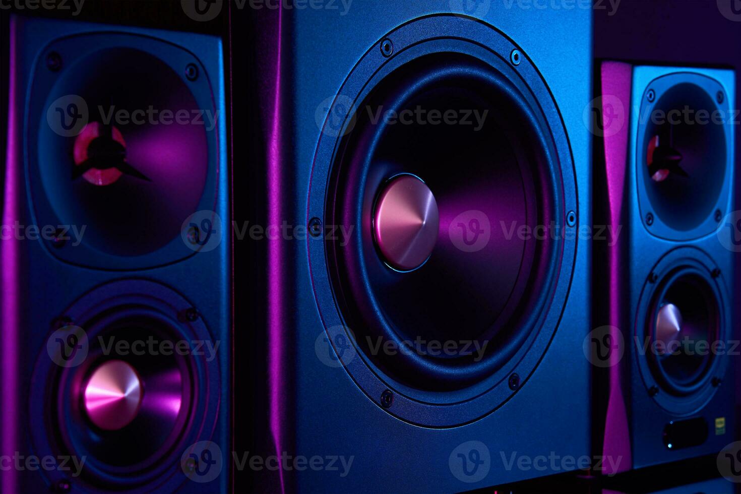 Two sound speakers and subwoofer on dark background with neon lights photo