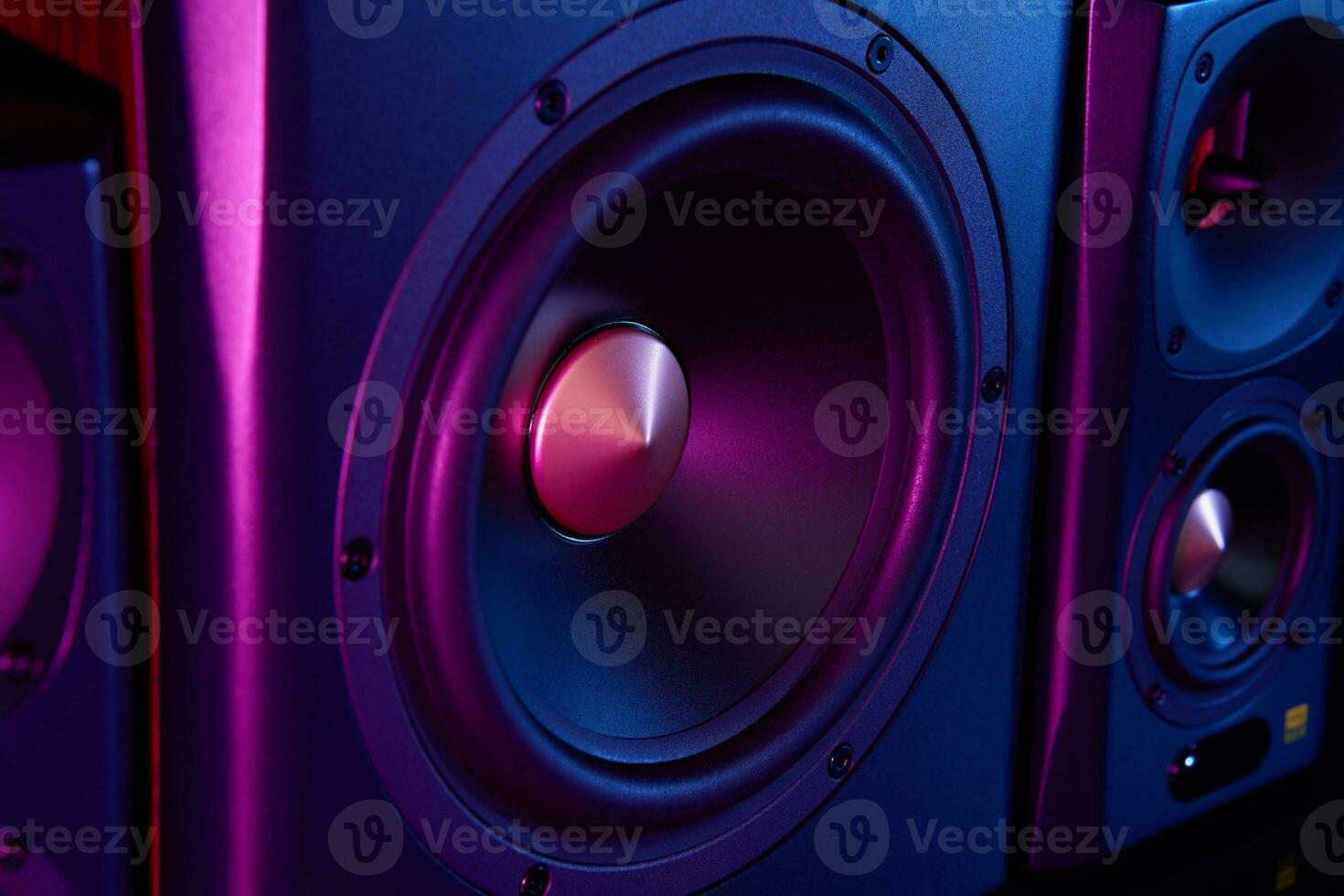 Two sound speakers and subwoofer on dark background with neon lights photo
