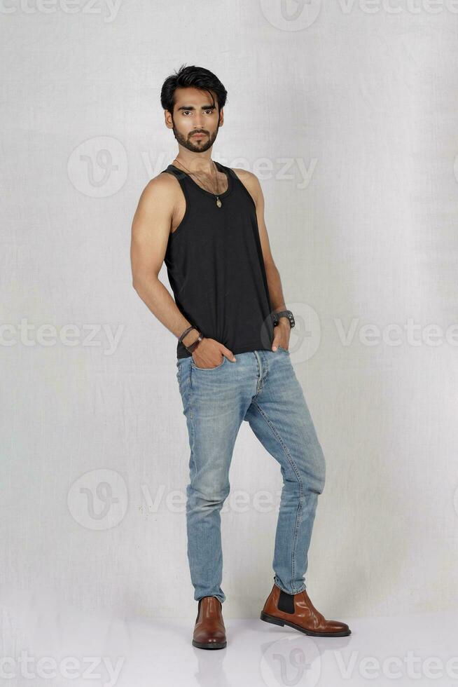a man in jeans and a black tank top photo