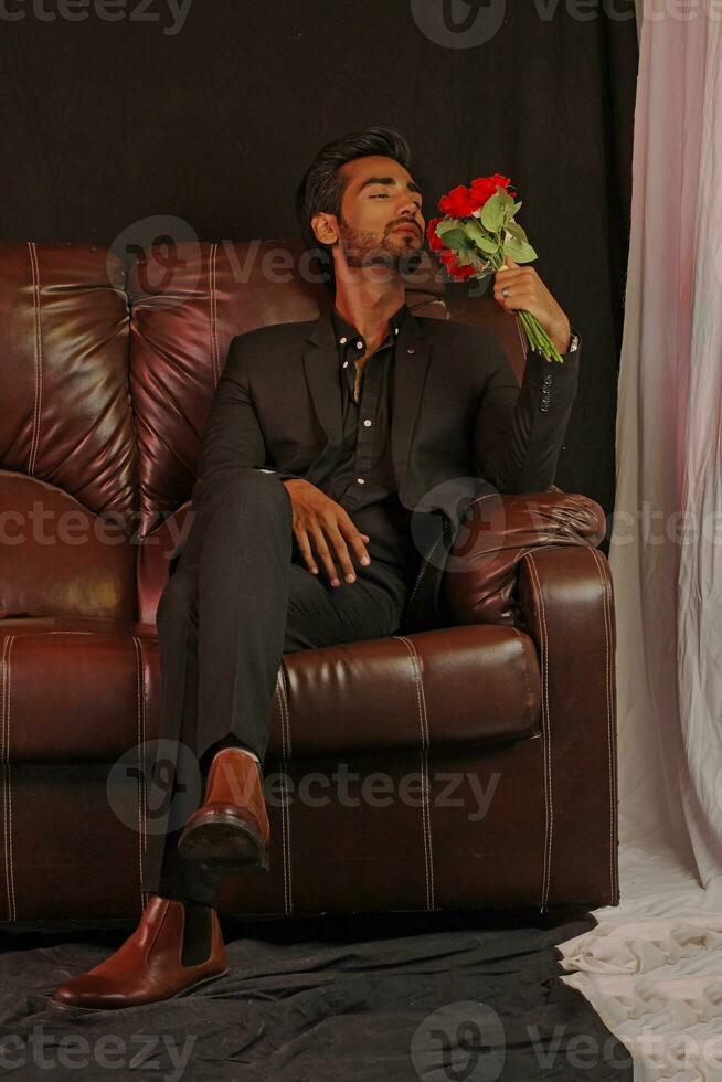 a man sitting on a brown leather couch photo