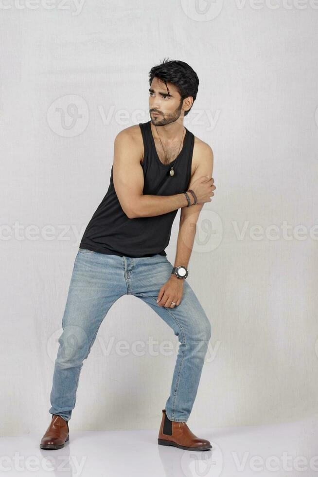 a man in jeans and a black tank top photo