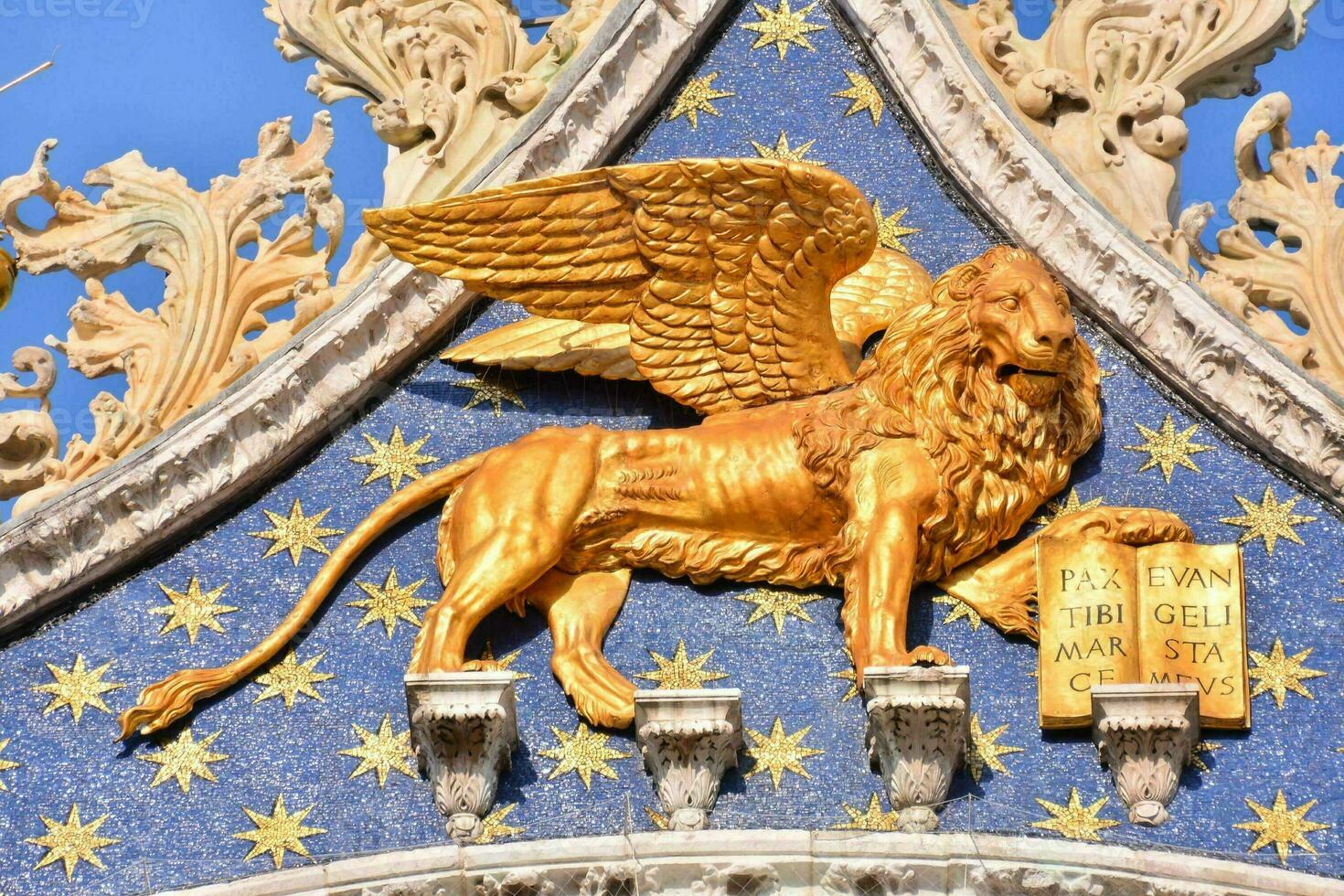 gold lion on the facade of the cathedral of venice photo