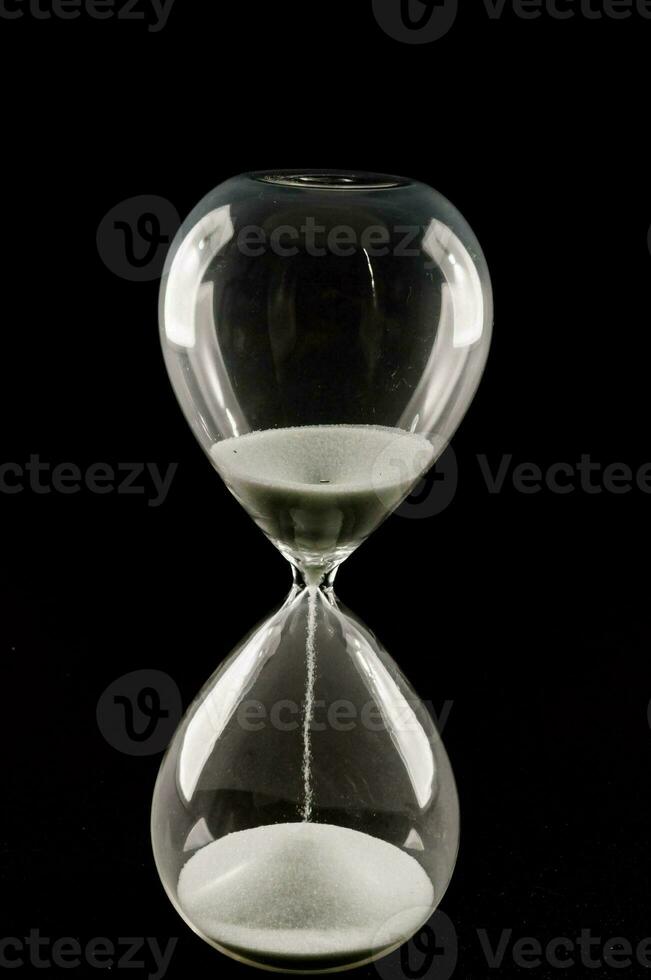 an hourglass on a black background photo