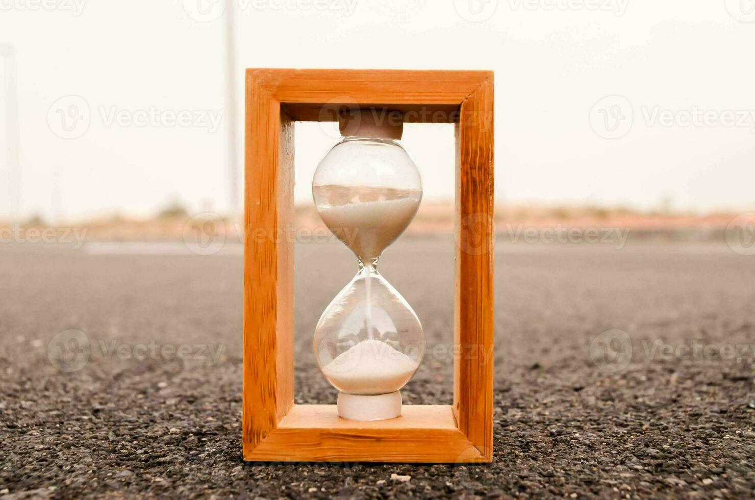 an hourglass sitting on the road photo