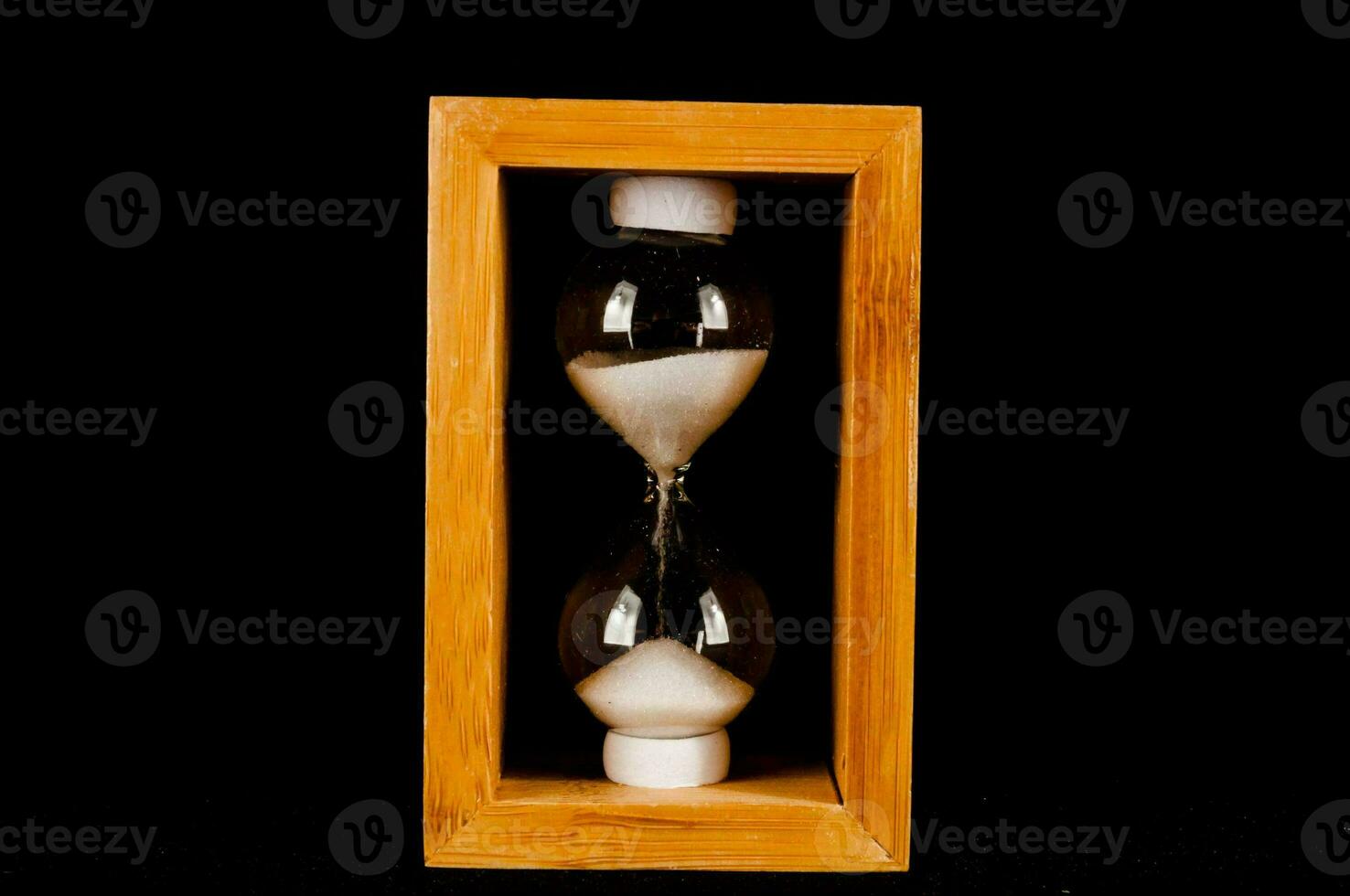 an hourglass in a wooden box on a black background photo