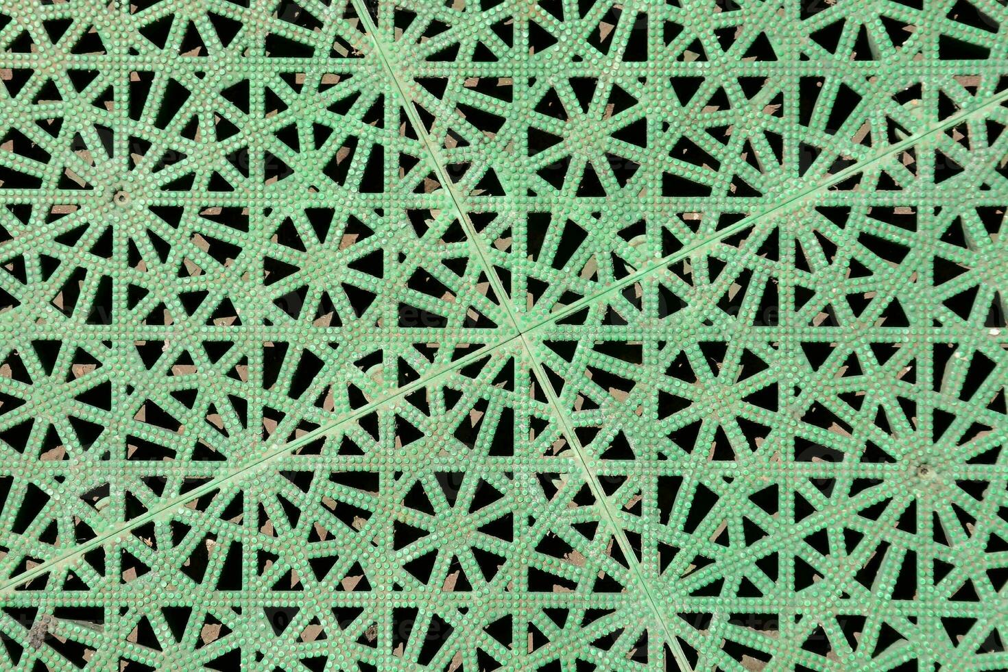 a green lattice pattern with holes in it photo