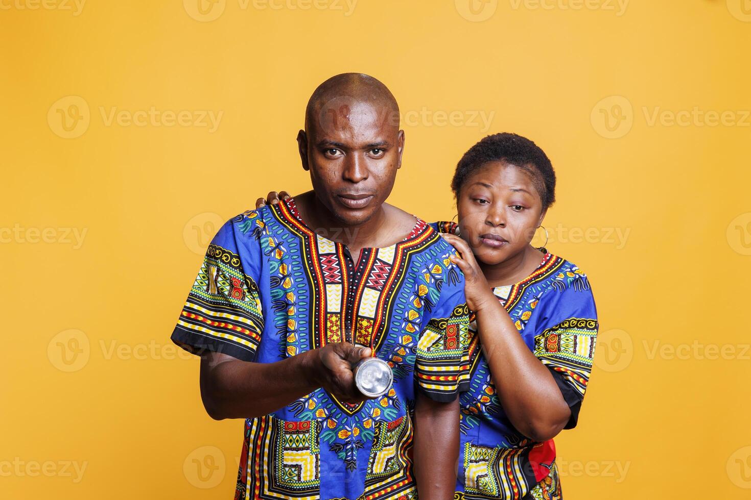 Confident man using flashlight and checking problem while terrified woman hiding behind back portrait. Anxious scared african american couple holding flash light and searching photo