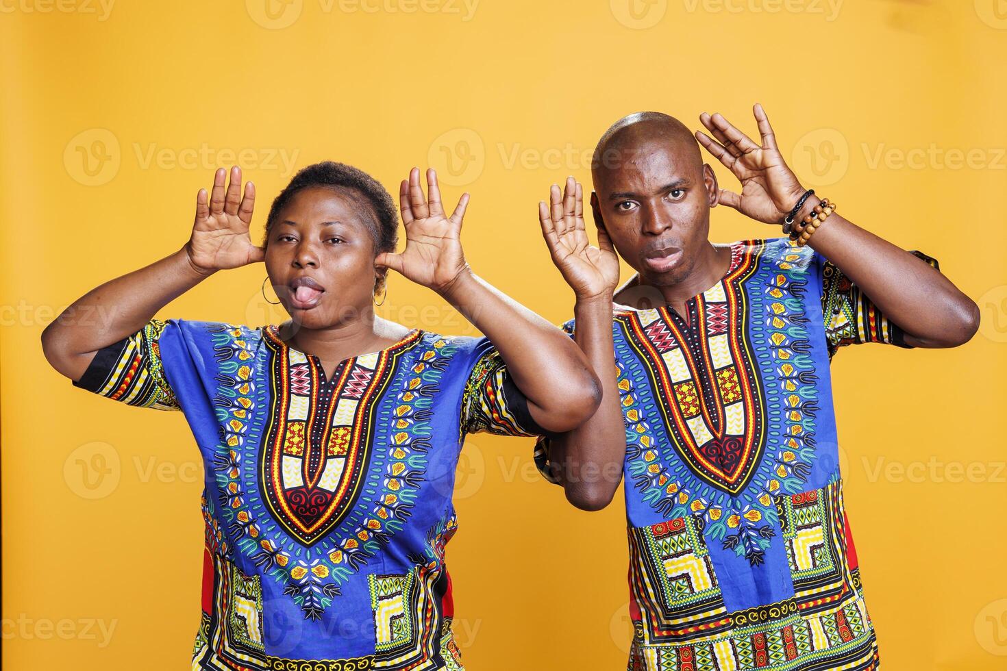 African american couple fooling around and showing silly grimace together portrait. Cheerful man and woman pair having fun, posing with comic face expression and looking at camera photo