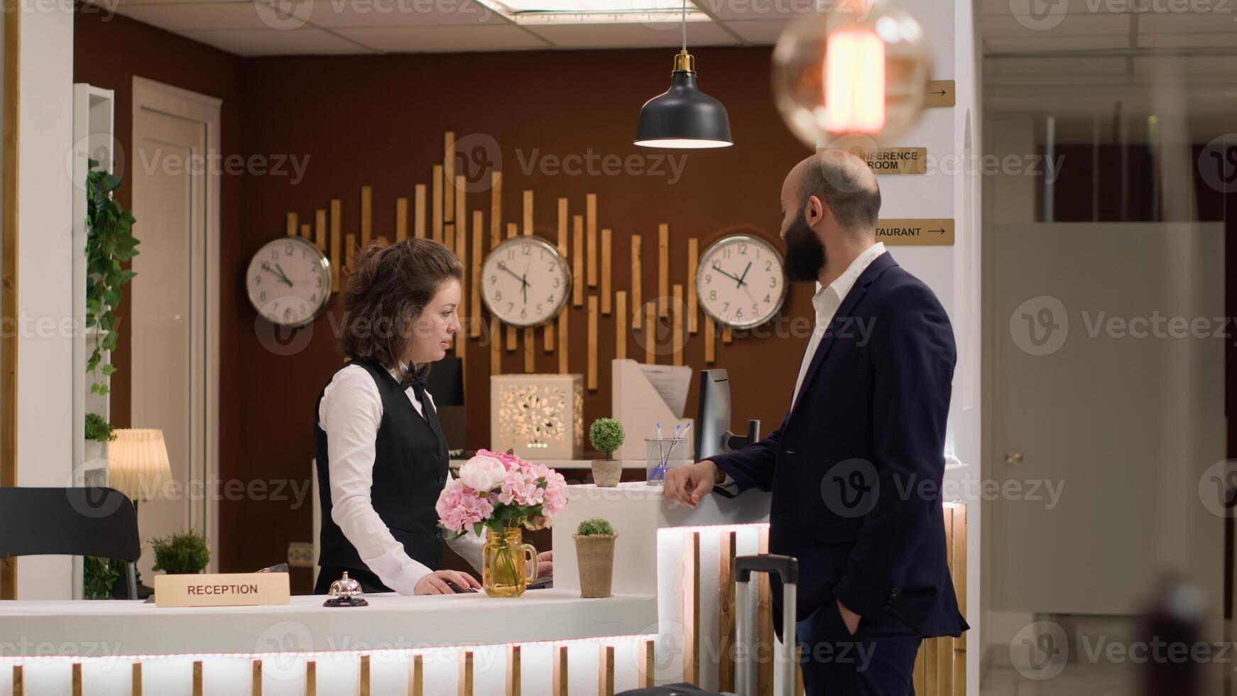 Hotel personnel providing luxury services for entrepreneur in suit en route to attend executive board meeting, reception lobby. Traveling on business trip, white collar worker doing check in. photo