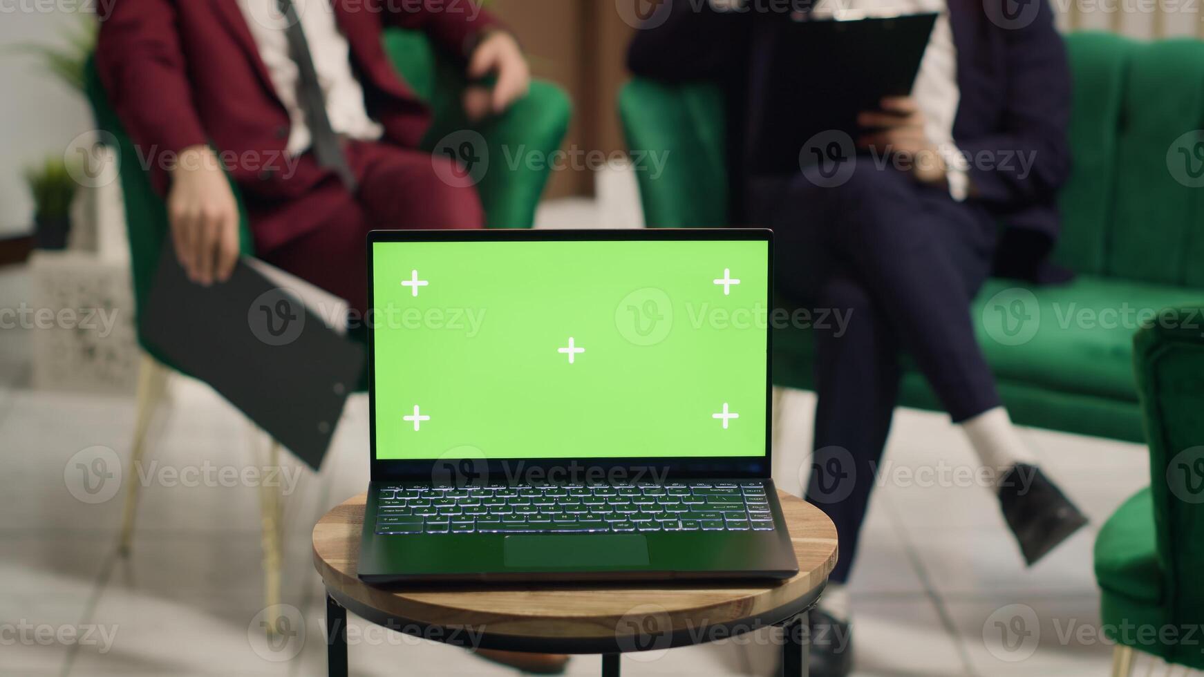 Greenscreen display on laptop in hotel lounge area, businessmen meeting to share new ideas at international conference. Wireless pc running isolated copyspace mockup template near front desk. photo