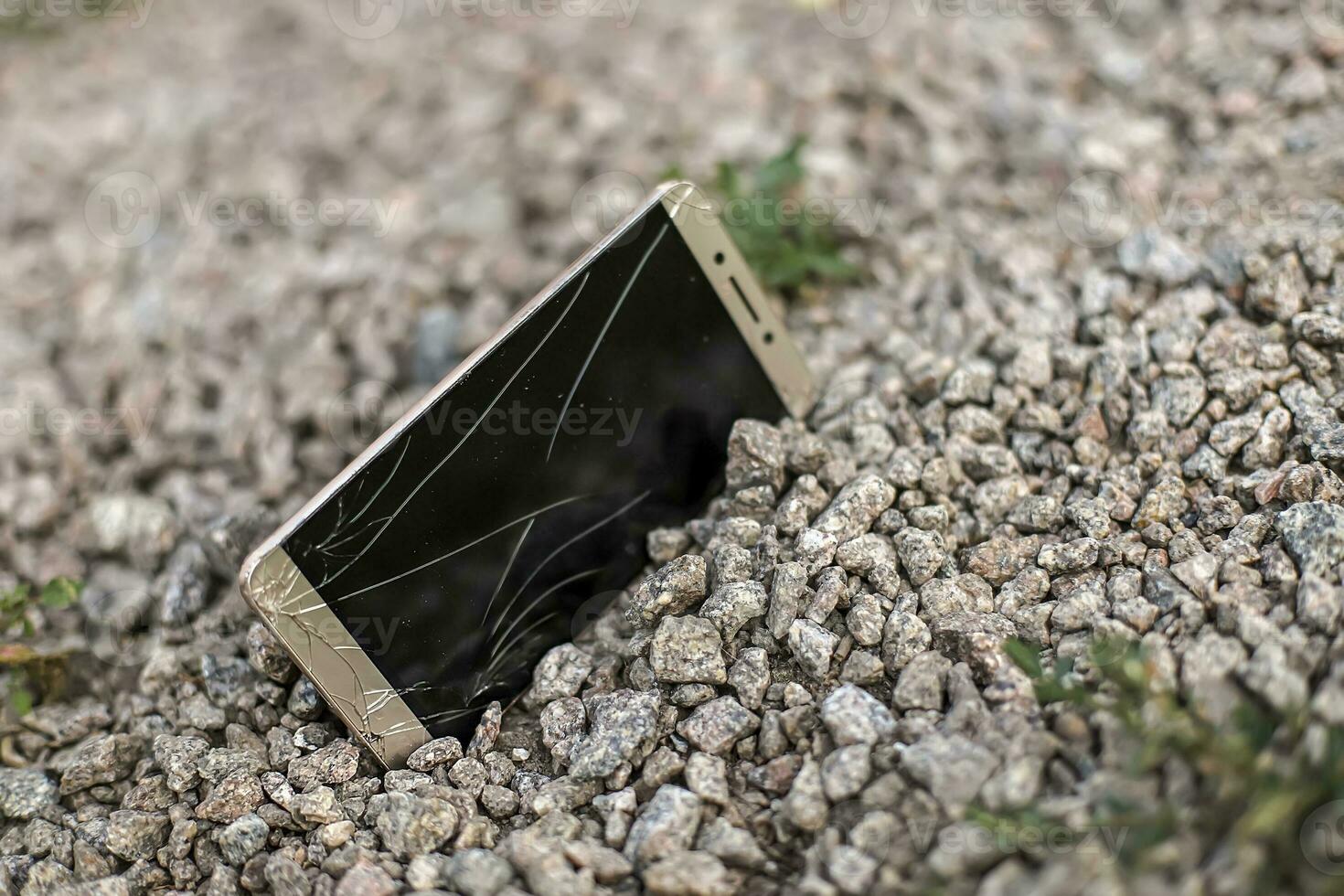 broken phone on stone paved sidewalk outdoors. Lost on walk smartphone with broken screen photo