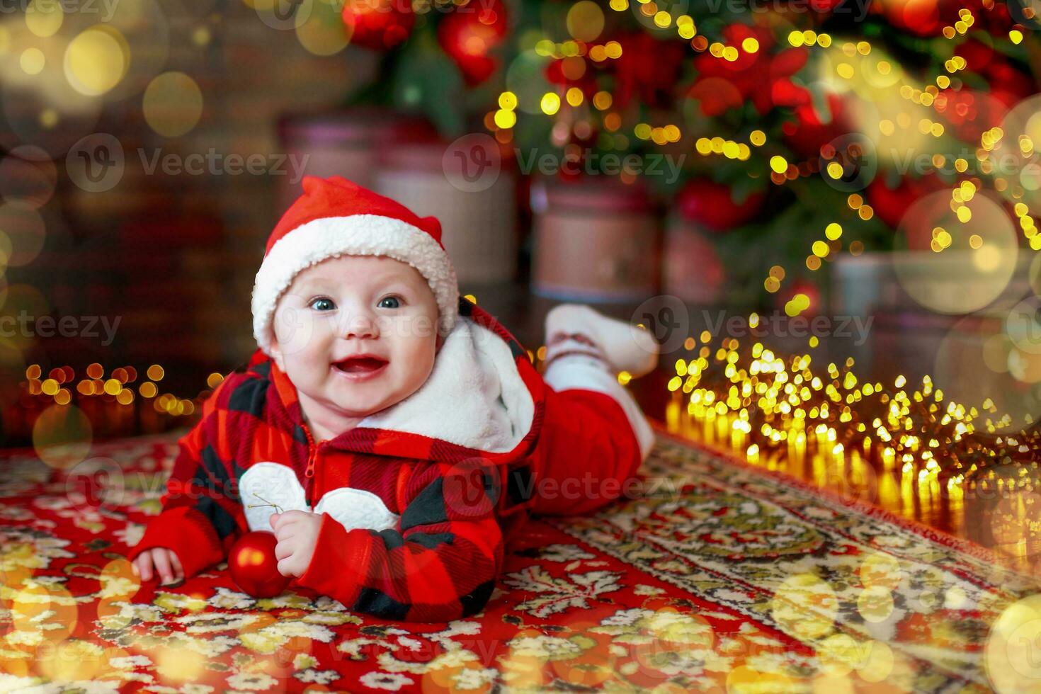 Little six month old baby dressed as Santa Claus. Background for christmas card. The child looks down at the place for inscription. photo