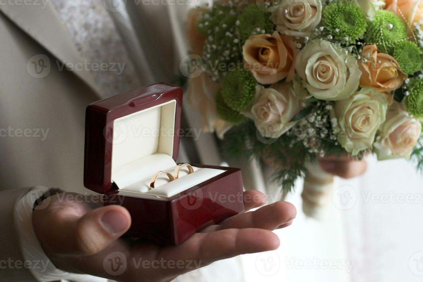 Groom holds wedding rings box photo