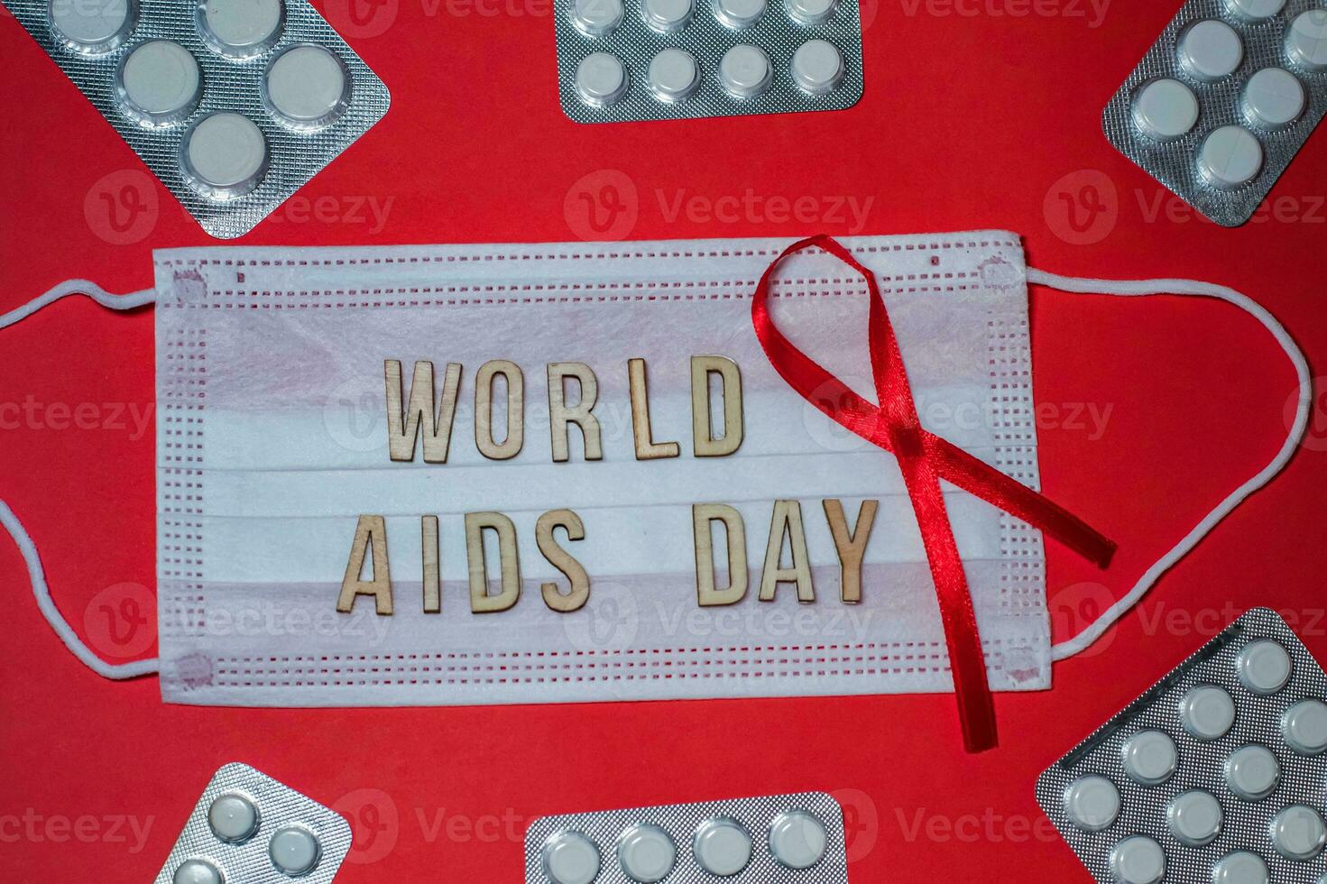 mundo SIDA día es fraseología en protector médico mascarilla. rojo cinta y pastillas en ampolla en rojo antecedentes foto