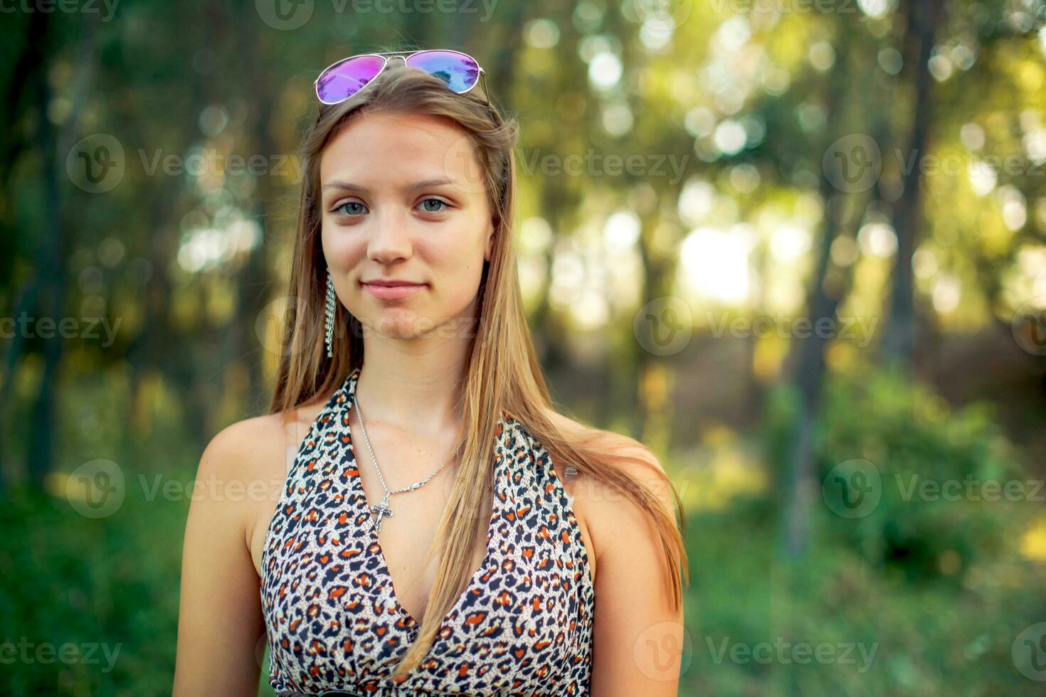 hermosa niña en un ligero Sarafan con desarrollando pelo en bosque antecedentes. niña es sonriente de pie. foto